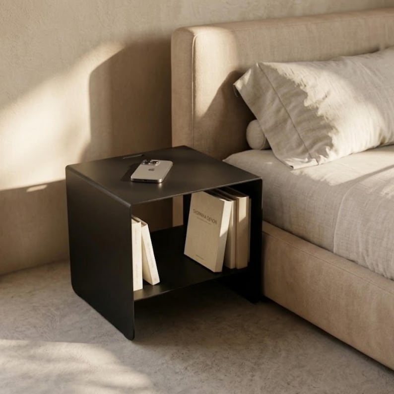 CARINI modern nightstand in powder-coated metal, shown with a clean industrial silhouette and practical internal shelf, perfect for storing books, magazines and small objects in contemporary bedrooms, loft interiors and minimalist living spaces.
