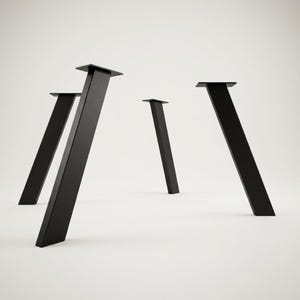Puede incluir: Un juego de cuatro patas de metal para muebles en color negro mate, cada una con un diseño cónico e inclinado y una placa de montaje rectangular plana en la parte superior. Estos componentes robustos están colocados en posición vertical y muestran un acabado uniforme.