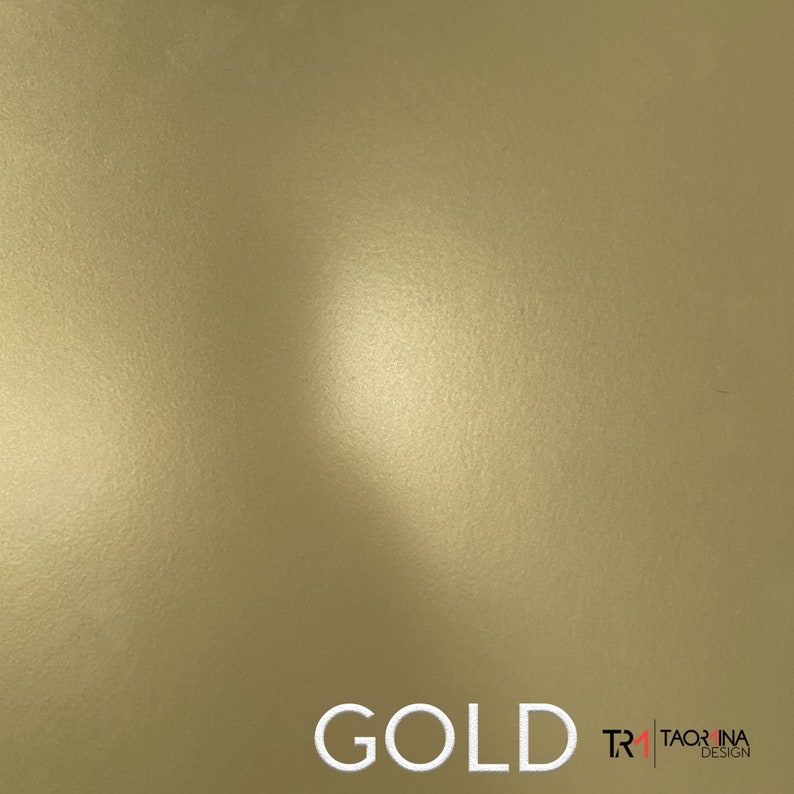 May include: A close-up of a gold metallic surface with a subtle textured pattern. The surface is illuminated by a soft light source, creating a gentle gradient effect. The word "GOLD" is displayed in white text at the bottom of the image, with the text "TR" and "TAORINA DESIGN" in smaller white text to the right.