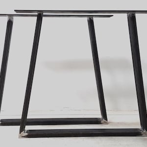 Peut inclure: Trois pieds de table en métal noir de forme triangulaire. Les pieds sont en métal épais et ont une finition mate.