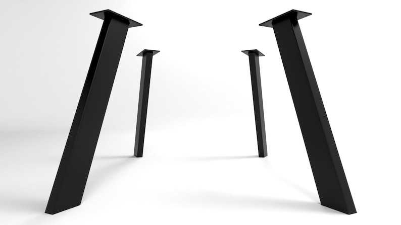 May include: Four black metal table legs with a square base and a slanted design. The legs are arranged in a symmetrical pattern, with two legs on each side.
