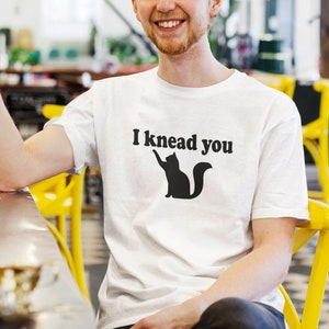 Cat pun T-shirt. I knead you kneading cat short sleeve graphic tee. Kitty biscuits animal pun shirt.