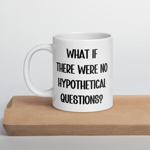 Puede incluir: Taza de café de cerámica blanca con texto negro que dice "What if there were no hypothetical questions?"