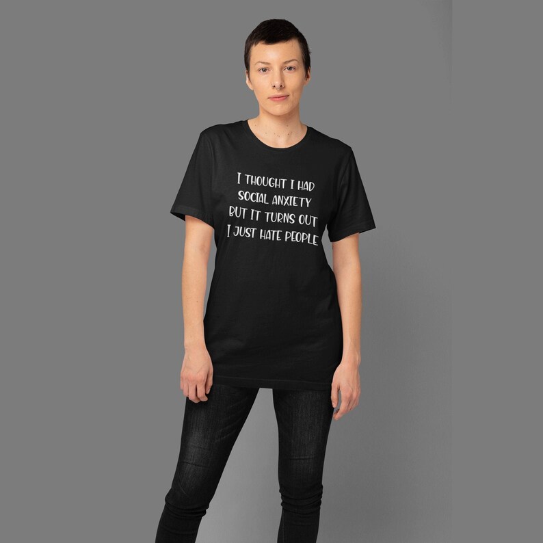 Woman wearing a black t-shirt with the phrase I thought I had social anxiety but it turns out I just hate people printed on the front.