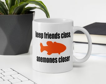 Sea anemone pun mug. Keep friends close, anemones closer. Friends and enemies funny pun dad joke mug.