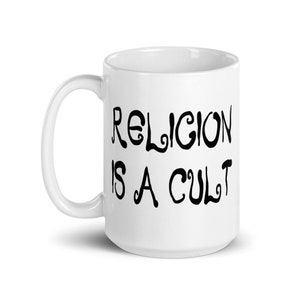 15 ounce white ceramic mug with the phrase Religion is a cult printed on both sides.