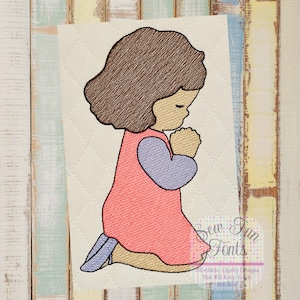 May include: Embroidered design of a girl with brown hair kneeling and praying with her hands clasped. She is wearing a pink dress with a purple sleeve and white shoes.