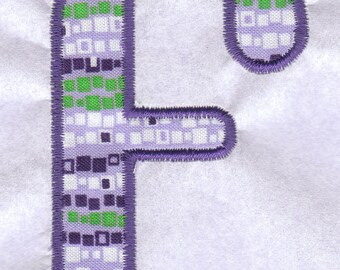 May include: Purple and green fabric letter F with a white background. The letter is made of a patterned fabric with a purple border.