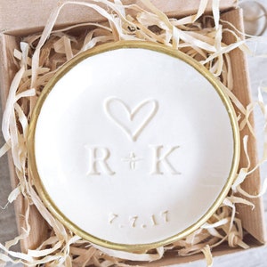 gold rim 3.5 inch glossy white ceramic wedding ring dish engraved with large heart, 2 name initials & date. Minimalist white on white design hand stamped clay pottery personalized wedding gift, wife anniversary present, jewelry trinket holder bowl