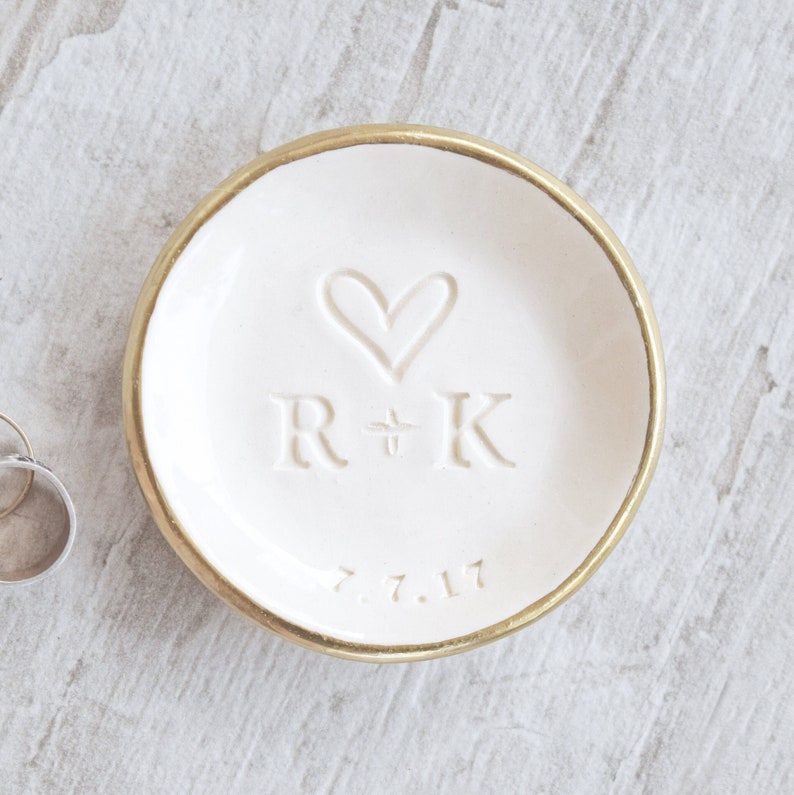 classic gold rim white gloss bowl ceramic wedding ring dish engraved with large heart, 2 name initials & date. Minimalist emboss design hand stamped clay pottery personalized wedding gift, wife anniversary present, jewelry trinket holder bowl