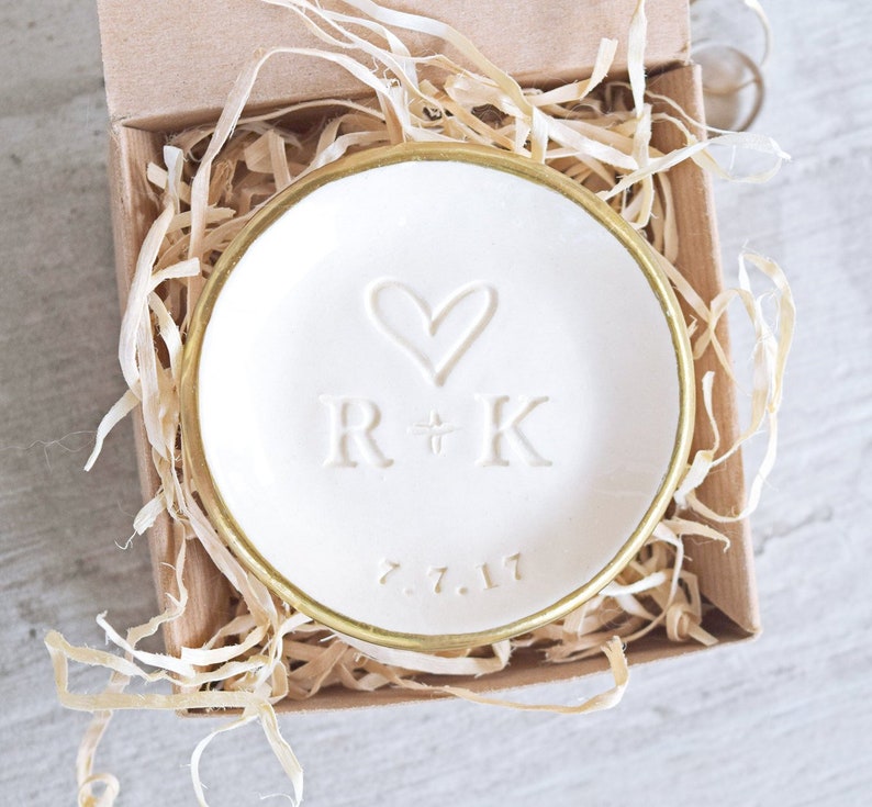 gold rim 3.5 inch glossy white ceramic wedding ring dish engraved with large heart, 2 name initials & date. Minimalist white on white design hand stamped clay pottery personalized wedding gift, wife anniversary present, jewelry trinket holder bowl