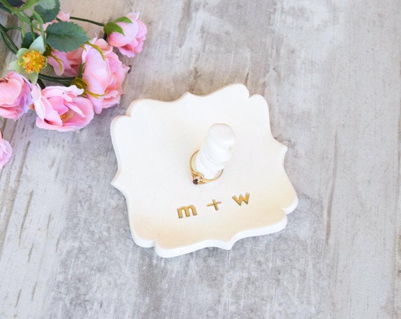 custom gold monogram personalize ring dish with post is large fancy square ceramic tray, handmade pottery jewelry storage with 2 inch tall ring cone in center. Engraved with 2 gold initials letters, wedding ring holder engagement gifts for couples.