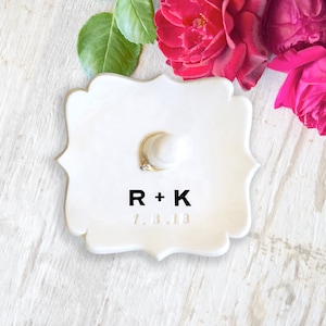 custom black monogram personalize ring dish with post is large fancy square ceramic tray, handmade pottery jewelry storage with 2 inch tall ring cone in center. Engraved with 2 gold initials letters, wedding ring holder engagement gifts for couples.