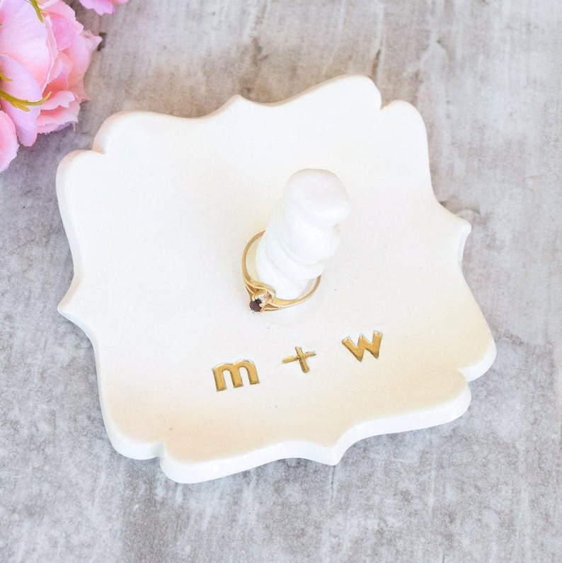 custom gold monogram personalize ring dish with post is large fancy square ceramic tray, handmade pottery jewelry storage with 2 inch tall ring cone in center. Engraved with 2 gold initials letters, wedding ring holder engagement gifts for couples.