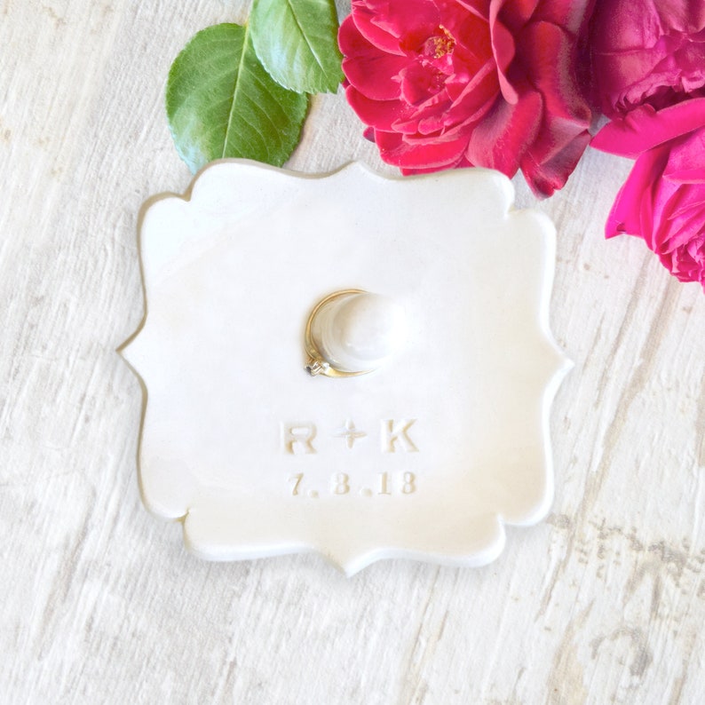 custom gold monogram personalize ring dish with post is large fancy square ceramic tray, handmade pottery jewelry storage with 2 inch tall ring cone in center. Engraved with 2 gold initials letters, wedding ring holder engagement gifts for couples.