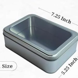 May include: A medium-sized, rectangular, silver-colored tin box. The box measures 7.25 inches long, 5.25 inches wide, and 2.25 inches deep. The interior is a lighter shade of silver. The text "Medium Size" is displayed on the bottom left.