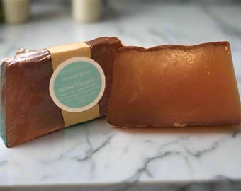 May include: Two bars of brown soap with a label that reads "Volcan Soap,  lavender & citrus,  purely organic,  handcrafted with love,  100g".