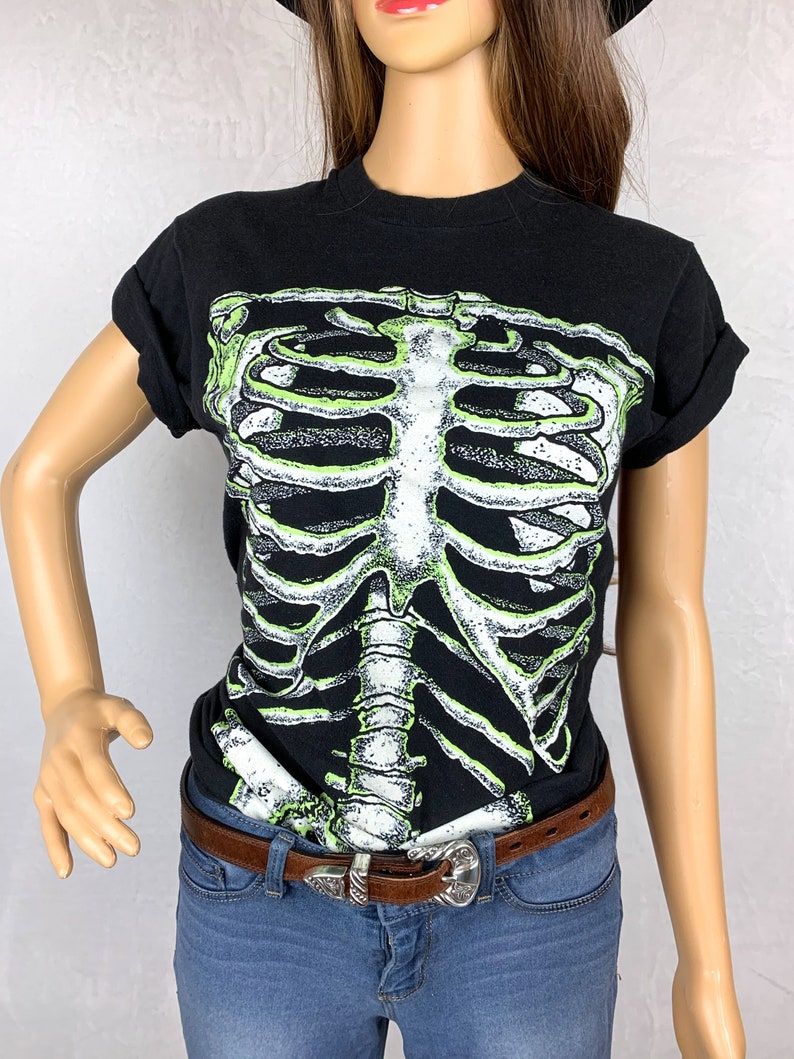 Op de afbeelding: Zwart T-shirt met een groene en witte skeletprint.