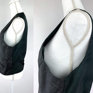May include: A black leather waistcoat with a V-neck and adjustable straps.