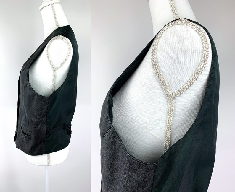 May include: A black leather waistcoat with a V-neck and adjustable straps.