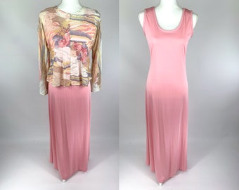 May include: A two-piece outfit featuring a long pink skirt and a sheer top with a floral print. The top has long sleeves and a scoop neckline.