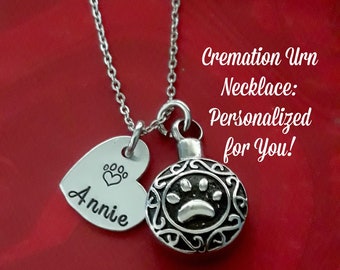 May include: Silver cremation urn necklace with a heart charm engraved with the name "Annie" and a paw print. The necklace is on a red background with the text "Cremation Urn Necklace: Personalized for You!"