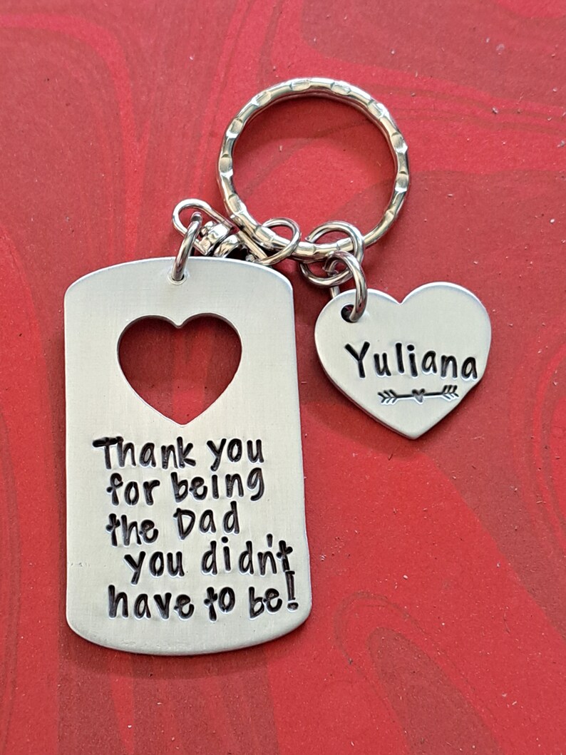May include: Silver keychain with a heart-shaped tag that says "Thank you for being the Dad you didn't have to be!" and a smaller heart-shaped tag with the name "Yuliana" on it.