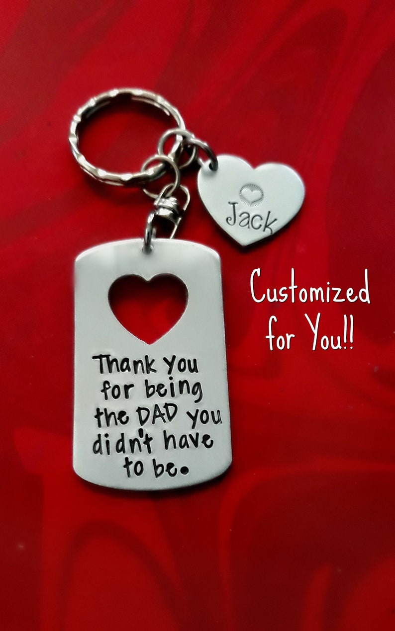 May include: Silver keychain with a heart-shaped tag that says "Thank You for being the DAD you didn't have to be." and a smaller heart-shaped tag that says "Jack".
