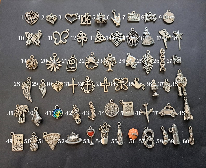May include: Sixty silver charm pendants with various designs, including hearts, butterflies, flowers, crosses, and a passport. The charms are numbered 1 through 60.