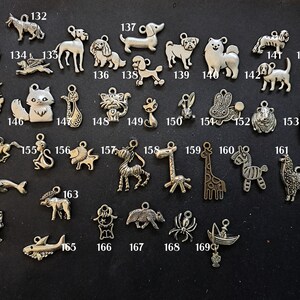 May include: A collection of silver charm pendants featuring various animal designs, including a dog, cat, horse, giraffe, zebra, and more. The charms are numbered 131 to 169.