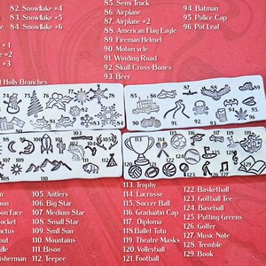 May include: A set of 129 metal stamp designs for crafting. The stamps feature a variety of images, including animals, plants, sports, and holiday themes. The stamps are arranged in rows on a red background.