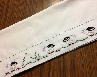 Puede incluir: Toalla de té blanca con pájaros bordados y follaje verde. Los pájaros son blancos con cabezas negras y vientres amarillos. El follaje es verde con bayas rojas.