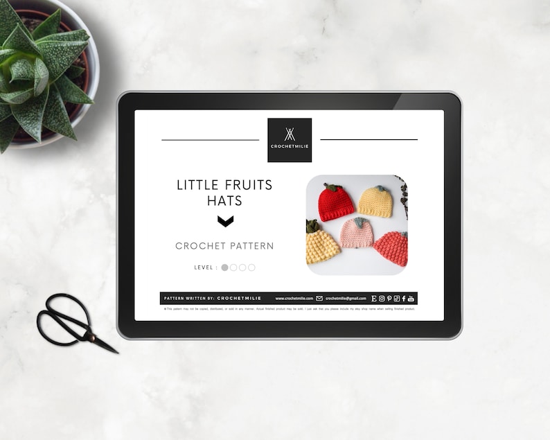 May include: A digital download crochet pattern for making little fruit hats. The pattern is labeled "Little Fruits Hats" and includes a photo of five crocheted hats shaped like strawberries, lemons, and peaches.
