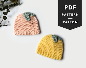 Puede incluir: Dos gorros de ganchillo, uno melocotón y otro amarillo, con hojas verdes en la parte superior. PDF PATTERN PATRON está escrito en texto negro sobre fondo negro.