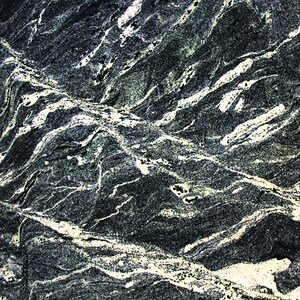 May include: Close-up of a dark grey stone with white and light grey veins. The stone has a rough, textured surface.
