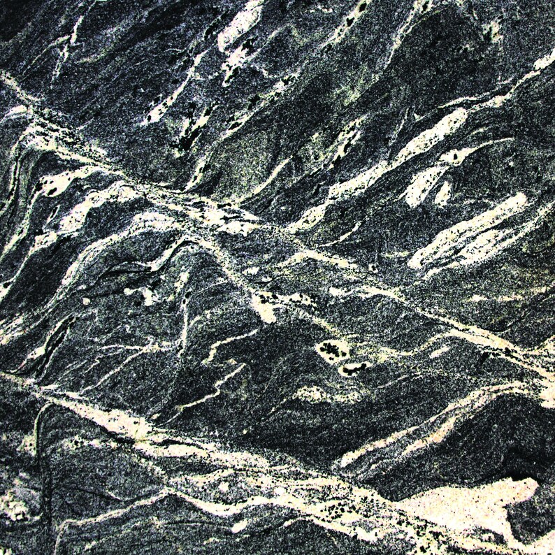 May include: Close-up of a dark grey stone with white and light grey veins. The stone has a rough, textured surface.