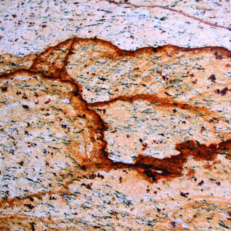 Puede incluir: Primer plano de una encimera de granito de color marr&oacute;n claro, beige y naranja con un patr&oacute;n de vetas marrones oscuras en espiral.