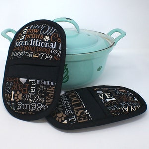 Könnte beinhalten: Zwei schwarze Ofenhandschuhe mit einem Hunde-Motiv. Der Druck enthält die Wörter "Paw Prints", "Unconditional Love", "Best Dog Ever", "Wagging Tail", "Fetch", "My Dog", "Walk", "Sit", "Stay", "Loyal", "Best Friend" und "Love".