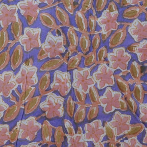 Puede incluir: Una tela con un estampado floral repetitivo. El diseño presenta flores rosas y hojas marrones sobre un fondo morado. El patrón es denso y cubre toda la superficie de la tela.