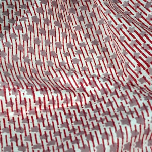 Puede incluir: Tela blanca con un patrón de rayas rojas y grises. El patrón presenta pequeñas formas grises que parecen flores.