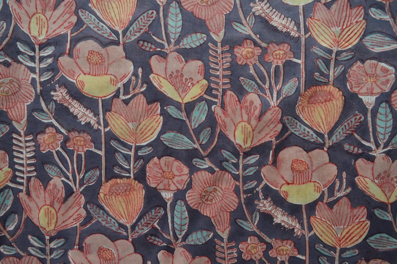 Pu&ograve; includere: Un tessuto blu scuro con un motivo ripetitivo di fiori rosa e gialli. I fiori hanno un aspetto stilizzato, disegnato a mano e sono circondati da foglie verdi.