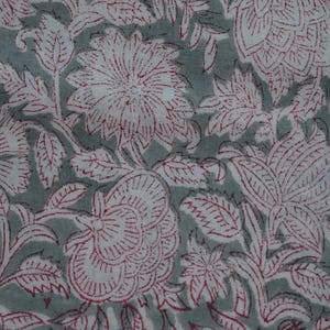 Puede incluir: Una tela con un patrón floral repetitivo de contornos rojo oscuro sobre un fondo verde salvia apagado. El diseño consta de varias flores y hojas estilizadas, creando un estampado botánico denso y continuo en toda la superficie textil.