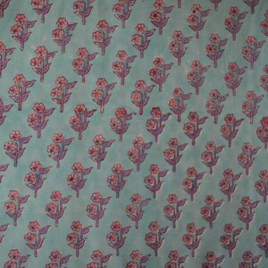 May include: A repeating pattern of stylized floral sprigs on a teal background. Each sprig features pink flowers and purple stems and leaves. The design is evenly spaced across the fabric.