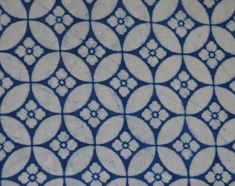 Pode incluir: Um padrão repetitivo de ovais brancos e desenhos florais azuis. O padrão é uma visão de perto de um tecido ou papel com uma estética tradicional. As flores são pequenas e têm cinco pétalas.