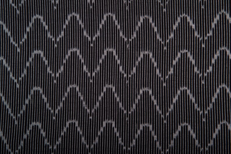 May include: Black fabric with a repeating pattern of vertical lines and a subtle wave design.