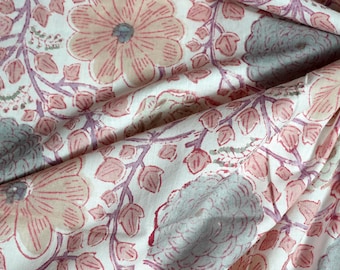 May include: A white fabric with a pink and gray floral print. The fabric has a soft, flowing texture and is perfect for crafting or sewing projects.
