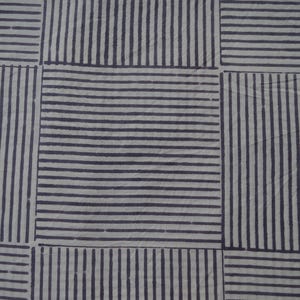 May include: A white fabric with a pattern of black stripes forming a grid.