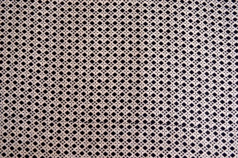 May include: A white fabric with a black diamond pattern.