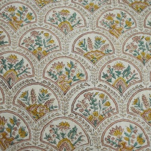 May include: A white fabric with a repeating pattern of pink, green, and yellow floral designs. The floral designs are arranged in a fan shape and are repeated across the fabric.