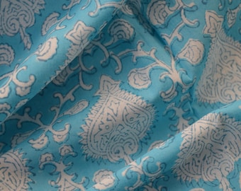 May include: A blue fabric with a white floral pattern. The fabric is folded in half, showing the pattern on both sides.